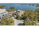 Coastal home featuring lush landscaping, a private dock, and convenient garage parking with stunning ocean views at 140 N Casey Key Rd, Osprey, FL 34229