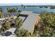 Coastal residence with a gray roof, surrounded by lush landscaping and a spacious driveway, blending with nature at 140 N Casey Key Rd, Osprey, FL 34229