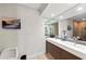 Bright bathroom featuring dual sinks, modern fixtures, and a large mirror at 140 N Casey Key Rd, Osprey, FL 34229