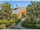 Charming coastal home with a stone pathway, surrounded by lush greenery, offering a serene and private retreat at 140 N Casey Key Rd, Osprey, FL 34229