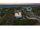 Beautiful beach house featuring palm trees and ocean views at sunset at 140 N Casey Key Rd, Osprey, FL 34229