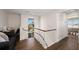 Hallway area with hardwood floors, railing, and a window with lush tropical scenery at 140 N Casey Key Rd, Osprey, FL 34229
