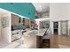 Modern kitchen featuring stainless appliances, large island with seating, and seamless integration with living spaces at 140 N Casey Key Rd, Osprey, FL 34229