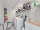 Clean laundry room with washer, dryer, shelving, and a utility sink at 140 N Casey Key Rd, Osprey, FL 34229