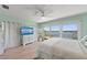 Light-filled main bedroom with water views, a ceiling fan, and sliding glass doors leading to the balcony at 140 N Casey Key Rd, Osprey, FL 34229