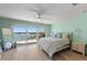 Bright bedroom with calming aqua walls, a ceiling fan, and sliding glass doors to the balcony at 140 N Casey Key Rd, Osprey, FL 34229