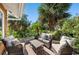 Outdoor seating area on deck is surrounded by lush greenery and palm trees at 140 N Casey Key Rd, Osprey, FL 34229