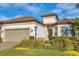 Front view of house with tile roof, two car garage, and manicured landscaping at 14608 Derna Ter, Bradenton, FL 34211