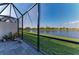 Enclosed patio overlooking a serene lake and well-manicured backyard at 15917 Clear Skies Pl, Lakewood Ranch, FL 34211