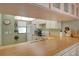 Galley style kitchen with white cabinets and wood countertops at 1651 Beach Rd # 408, Englewood, FL 34223