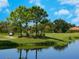 Golf course with lush landscaping, trees and calm water feature at 17459 Hickok Belt Loop, Bradenton, FL 34211