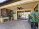 Covered patio with pavers, outdoor kitchen, and view of pool and lanai at 17459 Hickok Belt Loop, Bradenton, FL 34211