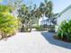 Landscaped backyard with gravel pathway and lush tropical plants at 18 N Casey Key Rd, Osprey, FL 34229