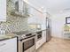 Stainless steel appliances and mosaic backsplash in this bright kitchen at 18 N Casey Key Rd, Osprey, FL 34229