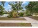 Yellow house with red door, driveway, and landscaped yard at 2202 Hyde Park St, Sarasota, FL 34239