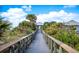 Wooden boardwalk leads to beach access with lush landscaping at 26720 Weiskopf Dr, Englewood, FL 34223