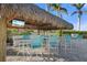 Relaxing tiki bar with seating and a TV at 26720 Weiskopf Dr, Englewood, FL 34223