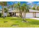 Tan house with green lawn, palm trees, and a two-car garage at 4212 Center Gate Ln # 2, Sarasota, FL 34233