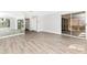 Living room with wood-look floors, large windows, and mirrored wall at 4212 Center Gate Ln # 2, Sarasota, FL 34233