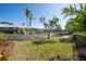 Large backyard with grassy area, white fence, and water view at 4419 Mangrove Point Rd, Bradenton, FL 34210