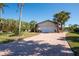 Single-story home with a paved driveway, landscaping, and palm trees at 4419 Mangrove Point Rd, Bradenton, FL 34210