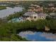 Elevated view showcasing the pool and clubhouse in a luxurious waterfront community surrounded by lush trees at 505 Sand Crane Ct, Bradenton, FL 34212
