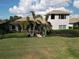 Landscaped backyard view showing the screened pool area, lush lawn, and rear exterior at 505 Sand Crane Ct, Bradenton, FL 34212