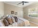 Bedroom features carpet, ceiling fan, multiple throw pillows, and a sunny window at 505 Sand Crane Ct, Bradenton, FL 34212