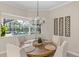 Bright dining room with a wood table and large window view of the screened pool at 505 Sand Crane Ct, Bradenton, FL 34212