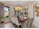 Elegant dining room with large window, stylish chandelier, and seating for six at 505 Sand Crane Ct, Bradenton, FL 34212
