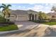 Beautiful home featuring a three-car garage, brick driveway, and well-maintained landscaping at 505 Sand Crane Ct, Bradenton, FL 34212