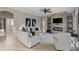 An open living room has tile floors, a ceiling fan, a stone fireplace, and modern furniture at 505 Sand Crane Ct, Bradenton, FL 34212