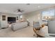 Living room with a ceiling fan, three windows, multiple seating options, and a large tv at 505 Sand Crane Ct, Bradenton, FL 34212