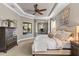 Inviting main bedroom featuring tray ceilings, a ceiling fan, and a charming window nook at 505 Sand Crane Ct, Bradenton, FL 34212