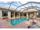 Screened in pool area, with a view of the outdoor kitchen, seating area, and patio, perfect for relaxation at 505 Sand Crane Ct, Bradenton, FL 34212