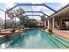 Inviting screened-in pool with a waterfall, surrounded by lush landscaping and a spacious deck with seating at 505 Sand Crane Ct, Bradenton, FL 34212