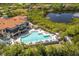 Aerial view of resort style pool and clubhouse with patio seating in a waterfront community at 505 Sand Crane Ct, Bradenton, FL 34212