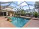 Relaxing screened-in pool area with a waterfall feature, outdoor kitchen, and comfortable seating at 505 Sand Crane Ct, Bradenton, FL 34212