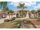 Beige house with tile roof, two-car garage, and lush landscaping at 5112 White Ibis Dr, North Port, FL 34287