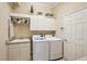 Bright laundry room with washer, dryer, cabinets, and sink at 5112 White Ibis Dr, North Port, FL 34287
