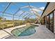 Inviting screened pool and spa with a tranquil waterfall feature at 5112 White Ibis Dr, North Port, FL 34287