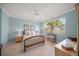 Serene bedroom with light blue walls, wood flooring, and a ceiling fan at 531 Latitude Ln, Osprey, FL 34229