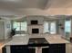 Open concept kitchen with island, white cabinets, and stone fireplace at 5317 19Th S Ave, Gulfport, FL 33707