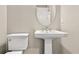 Modern powder room with pedestal sink and oval mirror at 5439 Taliaferro Ct, Palmetto, FL 34221
