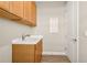 Functional laundry room with wooden cabinets and utility access at 5439 Taliaferro Ct, Palmetto, FL 34221