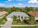 Single-Gathering home with gray roof, landscaping, and driveway, in a residential neighborhood at 557 Marsh Creek Rd, Venice, FL 34292
