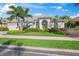 Single story home with a teal door and lush landscaping at 557 Marsh Creek Rd, Venice, FL 34292