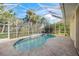 Enclosed pool and patio with stone tile flooring at 557 Marsh Creek Rd, Venice, FL 34292