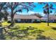 Home with spacious backyard, lush grass, and mature trees at 5828 Garden Lakes Dr, Bradenton, FL 34203