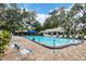 Community pool with lounge chairs and surrounding trees at 5828 Garden Lakes Dr, Bradenton, FL 34203